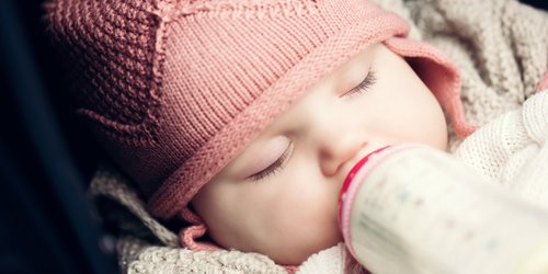 sleepy baby drinking milk