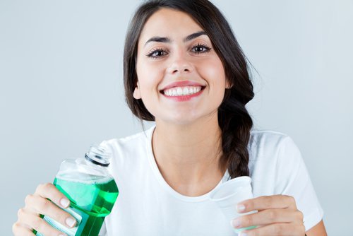 a woman take a sip of mouthwash before going to bed