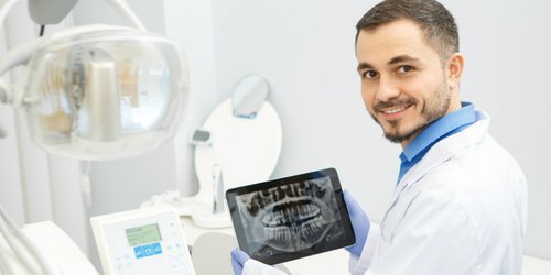 A doctor show his patient's teeth image on a routine check up