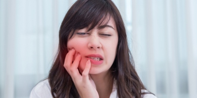 woman feels pain due to gumboil
