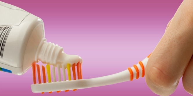 tooth paste being applied on toothbrush