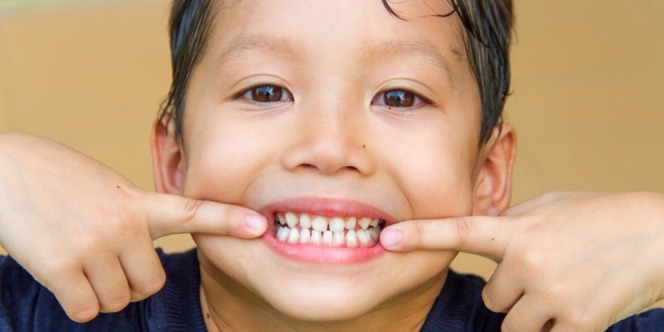 Kid showing off his healthy teeth grow